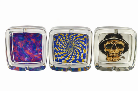 Three square glass ashtrays with different designs on a white background