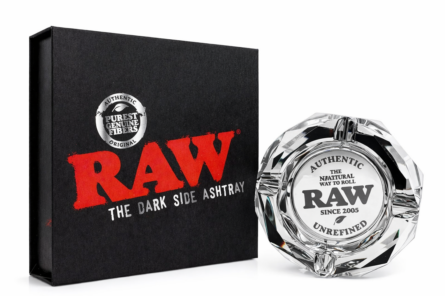 RAW Limited Edition Glass Ashtray displayed beside its black box packaging on a pure white background, featuring “RAW The Dark Side Ashtray” branding and engraved authentic RAW logo details.